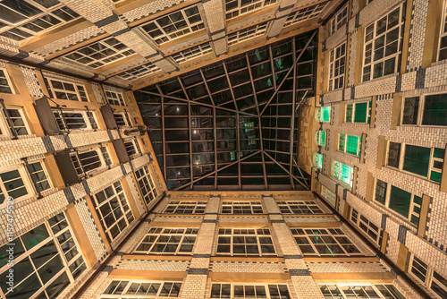 An impressive atrium view with large windows, a glass roof and green light accents in a harmonious, earthy design.