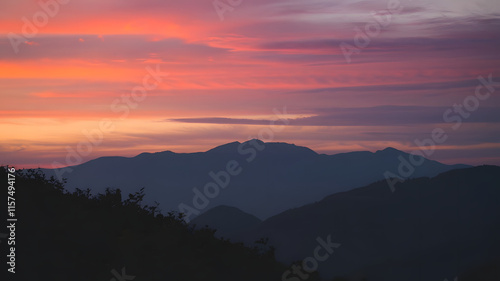 A photo of a mountainous landscape during sunset.