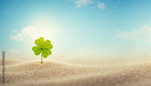 Four leaf clover in bright sunlight on sandy background with copy space