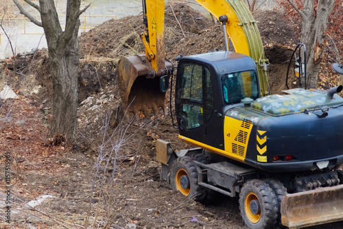 A construction excavator digs soil, creating a foundation pit for future development. photo