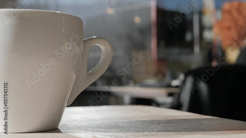 Close-up steaming hot tea or coffeein in white mug on a table in a cafe, close-up. Food court or restaurant in a shopping mall. People shopping and buying gifts. photo