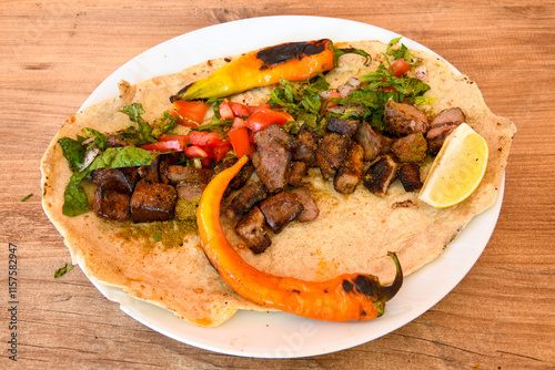 Famous Urfa meat liver, ciger wrapped by lavash with roasted chili pepper, onion and sauce in Sanliurfa, Turkey. Kuzu et ciger sis. Izgara dana bonfile, cop sis, kuzu pirzola. Karisik kebap, beyti keb photo