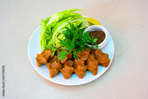 Cig kofte (raw meatball) with lettuce, tomato, pickle and lemon, hot Chee kofta. Turkish local raw food concept.Table scene of assorted take out or delivery foods. Doritoslu duble cig kofte durum. photo