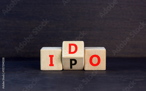 Initial public or DEX offering symbol. Concept words abbreviation IPO or IDO on wooden block. Beautiful black table black background. Business Initial public or DEX offering concept. Copy space. photo