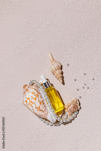 Elegant composition with seashells, pearls, and golden bottle photo