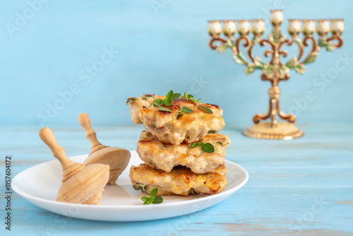 Chicken latkes (minced chicken cutlets) served with fresh thyme, wooden spinning tops for Jewish holiday Hanukkah. photo