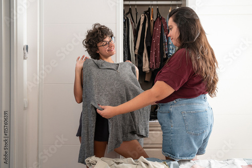 Loving lesbian couple enjoys choosing outfits together at home photo