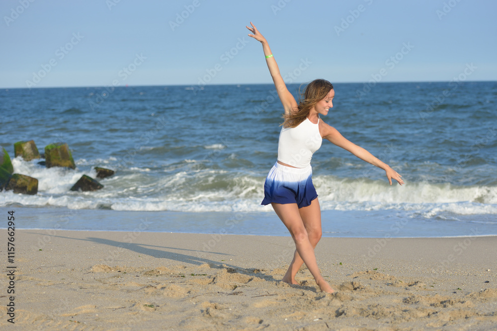 Beautiful young woman white tank top and blue & white skorts dances on the beach Beautiful young woman white tank top and blue & white skorts dances on the beach