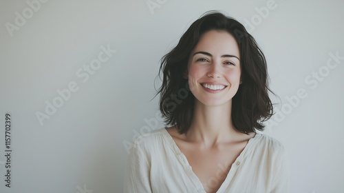Beautiful Smiling Woman with Straight Shoulder Length Dark Hair in Casual White Blouse Looking Directly at Camera on Plain White Background