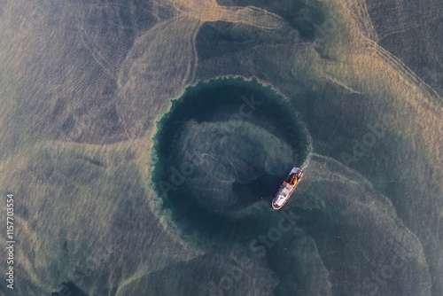 Drone image of the researching ship looking for fish in the blurred sea after rain and storm.