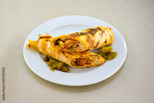 Lavash doner kebab ( soslu kasarli zurna doner durum )  or shawarma sliced in plate isolated.  Tavuk Et Doner Durum. Hatay Iskenderun usulu bazuka tavuk doner durum. photo