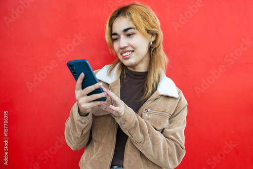 Mixed race woman using smartphone against vibrant red background photo