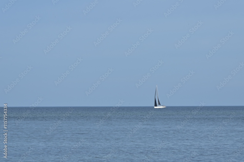 Obraz premium Einsames Segelboot auf dem offenen Meer