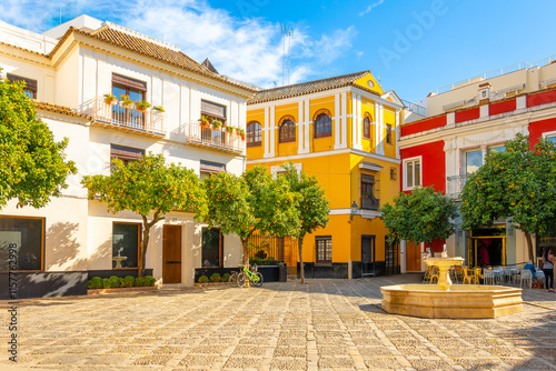 The colorful Plaza de la Alianza with water fountain and sidewalk cafe outside the Royal Alcazar in the Barrio Santa Cruz district of the Andalusian city of Seville, Spain.