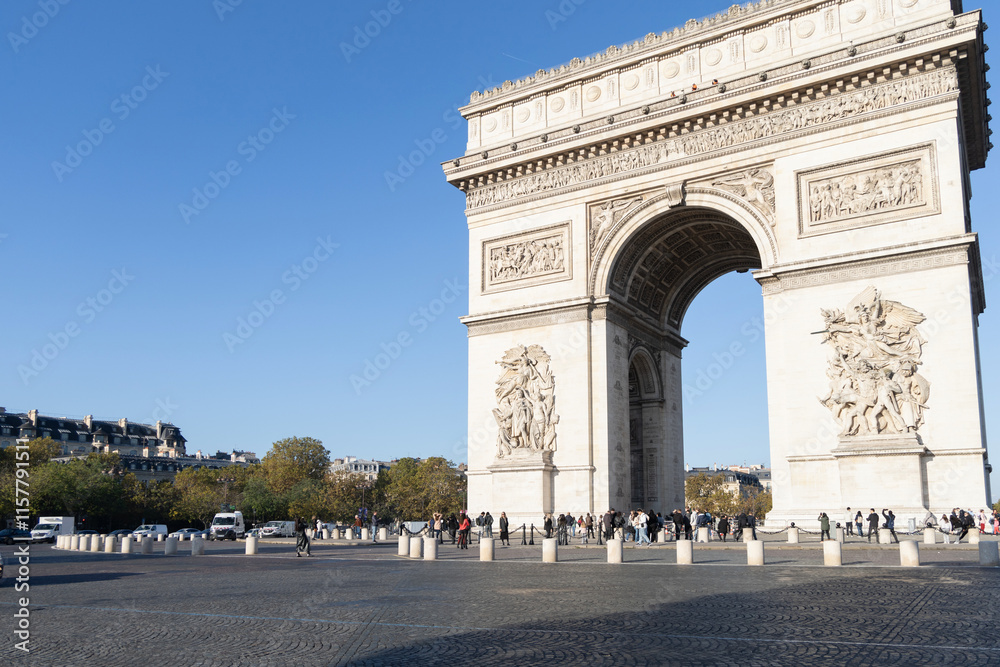 The Iconic Arc de Triomphe Majestically Stands Proudly Under a Clear Blue Sky in Paris, France The Iconic Arc de Triomphe Majestically Stands Proudly Under a Clear Blue Sky in Paris, France
