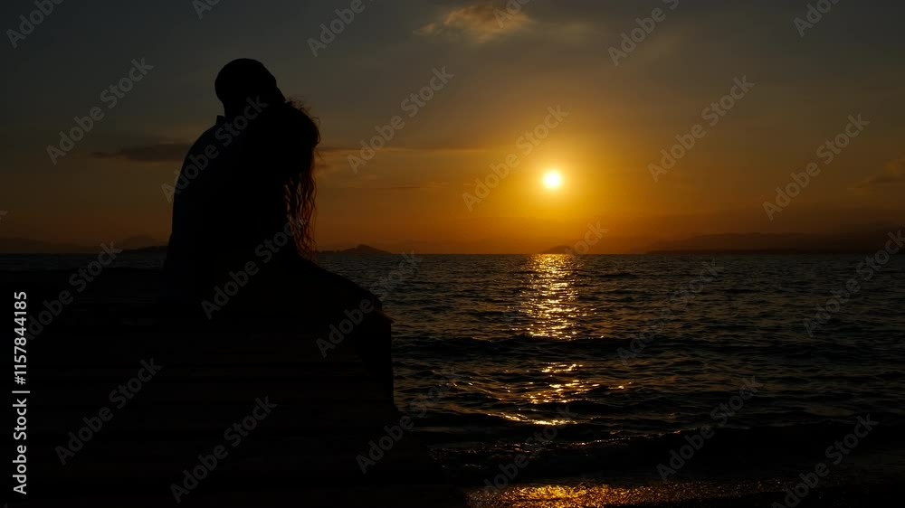 Father with child on evening wooden pier. A happy father with his little daughter silhouettes resting on the pier by the evening waves during summer weekend. Father with child on evening wooden pier. A happy father with his little daughter silhouettes resting on the pier by the evening waves during summer weekend.