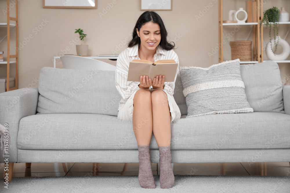Portrait of pretty young woman reading book on sofa at home Portrait of pretty young woman reading book on sofa at home