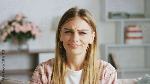 Obraz na plátně Young woman wearing casual clothes frowning on a sofa in her living room, expres