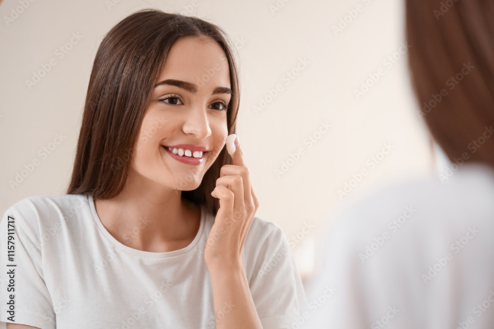 Young woman applying cream near mirror at home, closeup Young woman applying cream near mirror at home, closeup