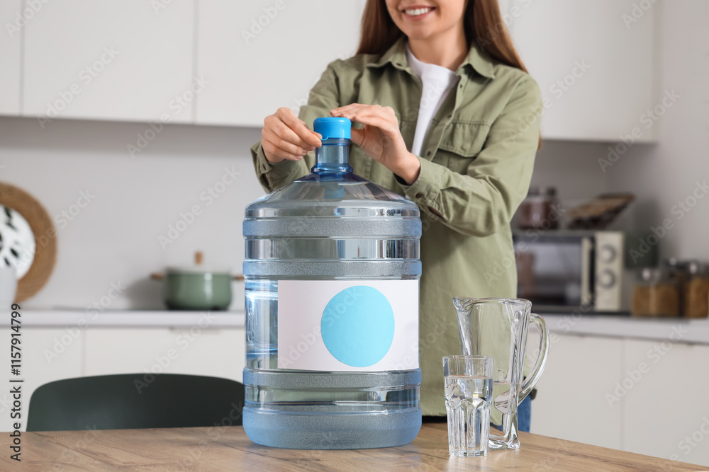 Woman opening bottle of clean water on table in kitchen Woman opening bottle of clean water on table in kitchen