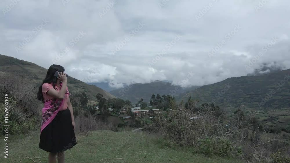 Video de una feliz y bonita campesina  hablando por un teléfono celular en los Andes peruanos. Mujer usando teléfono móvil. Quechua. Andes.