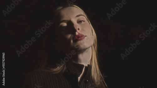 Fashion model posing in dark studio with dramatic
