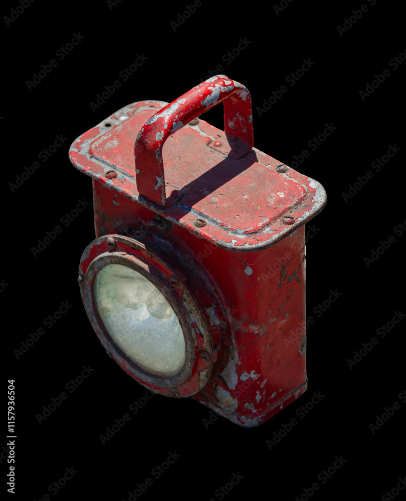 Old red metal lantern with a handle features a weathered and worn appearance, showcasing its rustic and industrial design.