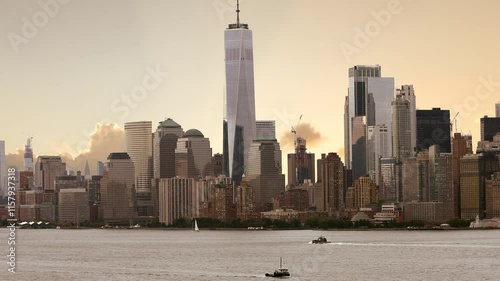 Manhattan skyline and New York City at sunrise with New York Harbor in foreground.