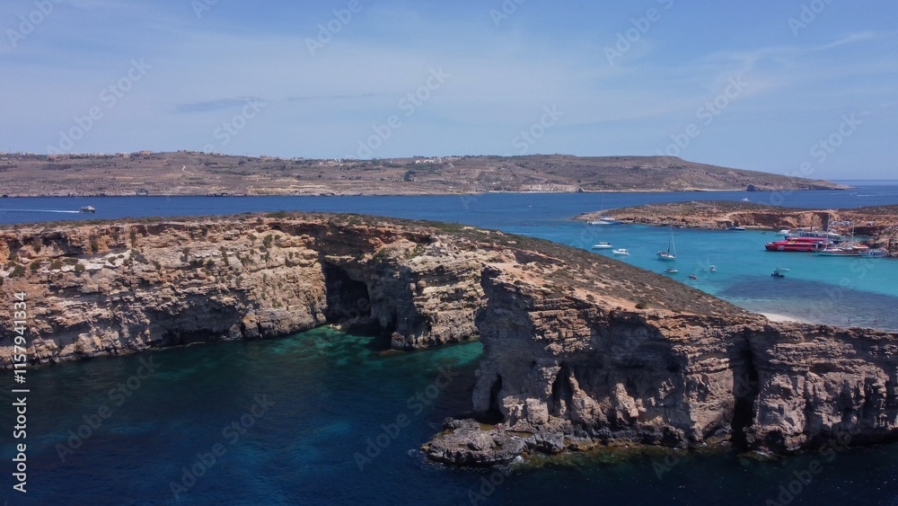 Aerial view of the sea caves of Cominotto uninhabited island near Comino, Maltese islands. Seagull flying in the frame. High quality photo Aerial view of the sea caves of Cominotto uninhabited island near Comino, Maltese islands. Seagull flying in the frame. High quality photo