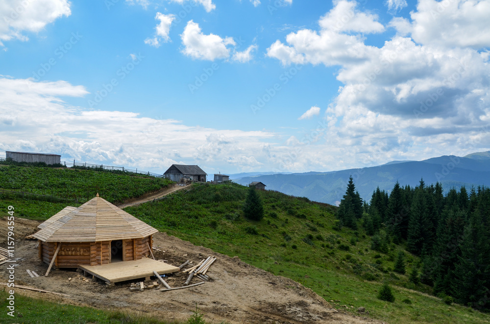 Rustic wooden cabin nestled in a lush, green mountainous landscape under a bright blue sky with fluffy clouds. Ideal for concepts of nature, tranquility, and rural living. Carpathians, Ukraine Rustic wooden cabin nestled in a lush, green mountainous landscape under a bright blue sky with fluffy clouds. Ideal for concepts of nature, tranquility, and rural living. Carpathians, Ukraine
