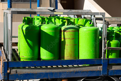 Pickup truck carrying LPG gas, bright green metal bottles with LPG gas background photo