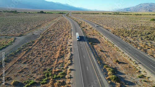 CALIFORNIA - 10.21.2024 - Fantastic aerial view of trucks driving down US Highway 395 in the Mojave Desert.