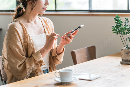 Wallpaper Mural カフェでコーヒーを飲みながらスマホを見る若いアジア人女性（待ち合わせ）
 Torontodigital.ca