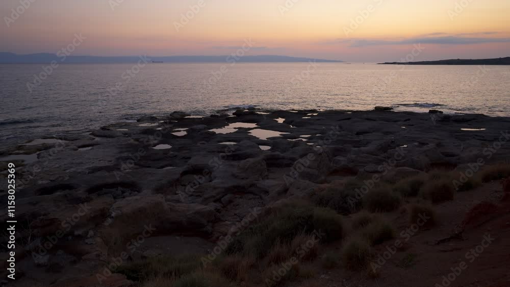 Natural holes on the rocks full with water at sunset with turquoise water sea of Greece on the background Natural holes on the rocks full with water at sunset with turquoise water sea of Greece on the background