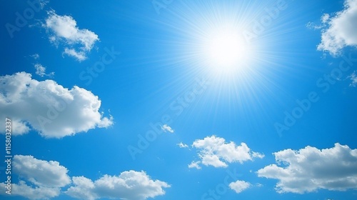 Bright sun shining in a clear blue sky with fluffy white clouds.