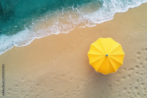 Aerial view of a yellow umbrella on a sandy beach by the ocean