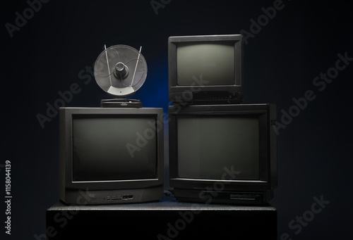 three vintage tvs with antenna on dark background for banner background photo