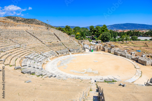 Stone amphitheater with a circular stage and stone wall surrounding it. Ruins of the ancient city of Philippi, Greece photo