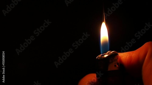 flame of a cigarette lighter in a smoker's hand