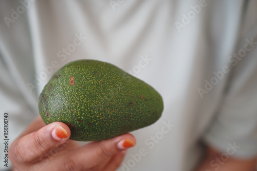 woman hand holding a slice of avocado  photo