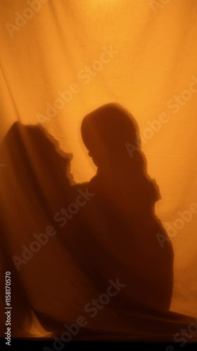 Mother throws up her baby and hugs, mom and child playing together at home. Happy parenting and caring motherhood. Silhouettes in vertical shot, unrecognizable people