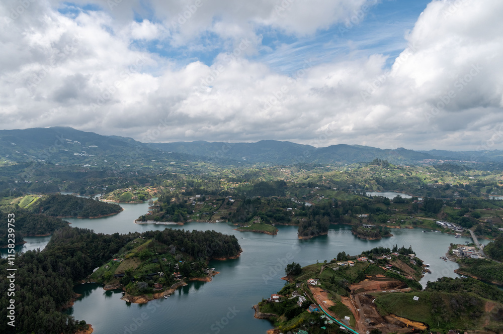 Serene landscape of rolling hills, tranquil waters, and lush greenery under a cloudy sky. Serene landscape of rolling hills, tranquil waters, and lush greenery under a cloudy sky.