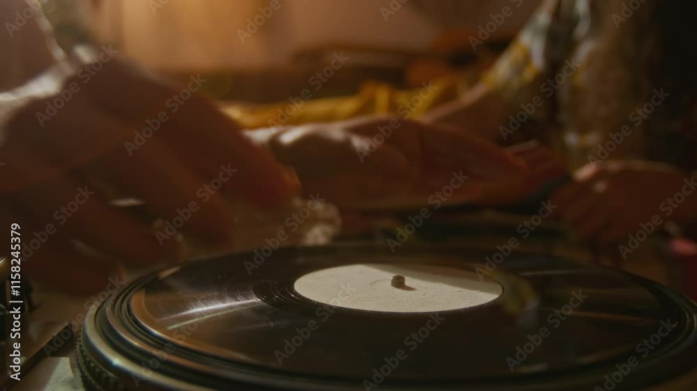 Close-up shot of hands of unrecognizable young woman or man putting vinyl record on player and setting up tonearm with needle, then listening to music and snapping fingers to rhythm