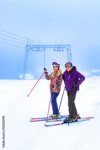 Obraz na płótnie Two father and daughter skiers enjoying a beautiful day on the slopes surrounded by nature and snow w salonie