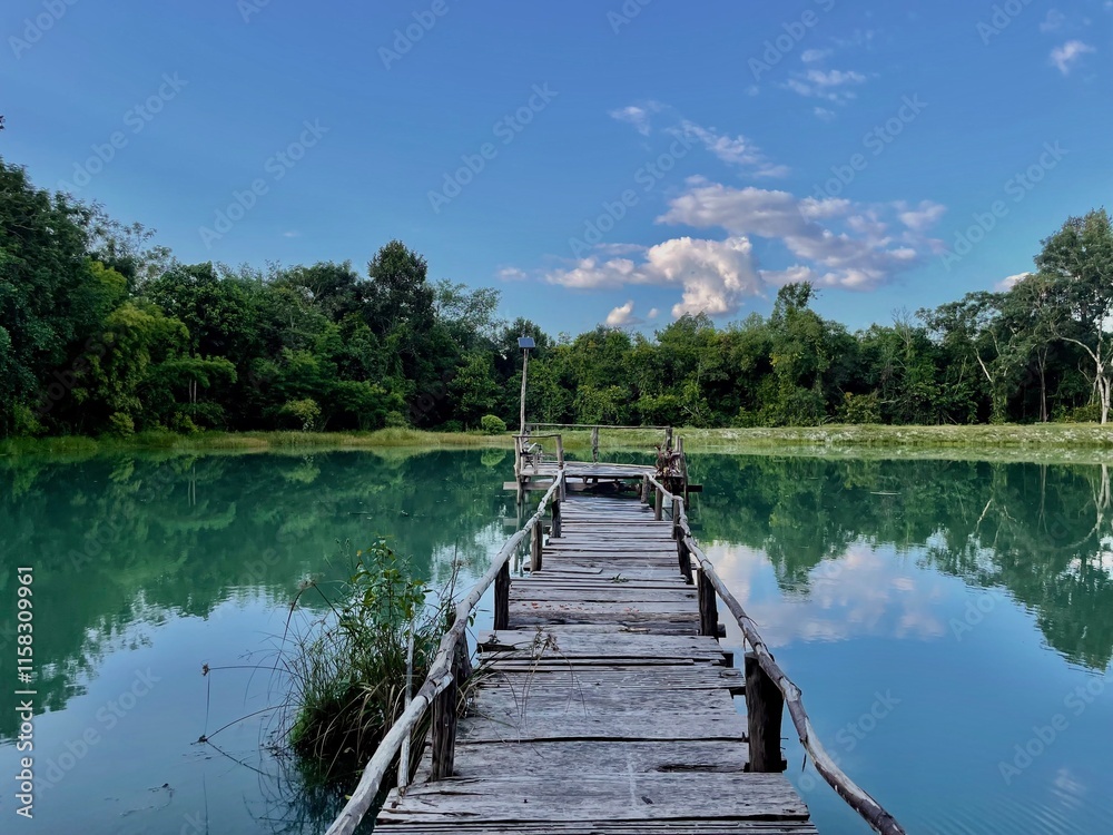 Photo zone on an old wooden bridge among a blue lake with a forest in the background Photo zone on an old wooden bridge among a blue lake with a forest in the background