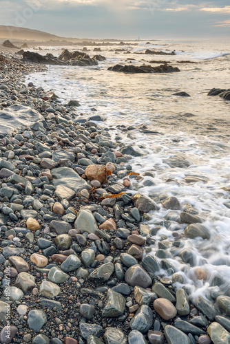 Rocky coastline of Barents Sea with dramatic clouds in the sky. Berlevåg, Finnmark, Northern Norway photo