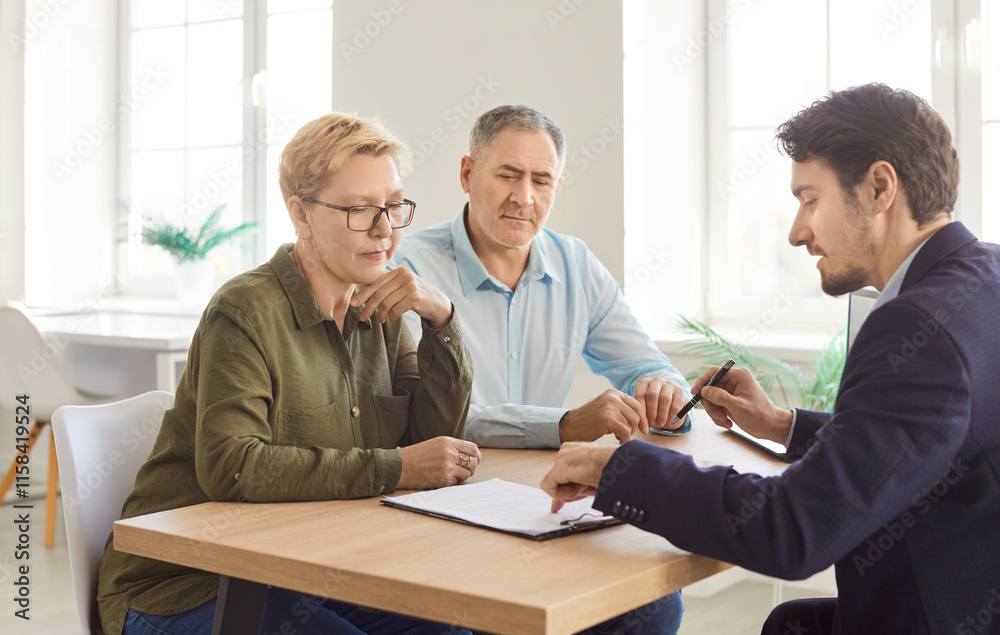 Senior couple discusses contract details with a consultant during an office meeting or negotiation. Topics include insurance, investment, and client-agent collaboration to finalize agreements. Senior couple discusses contract details with a consultant during an office meeting or negotiation. Topics include insurance, investment, and client-agent collaboration to finalize agreements.