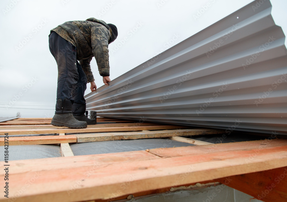 A man is working on a roof, painting it A man is working on a roof, painting it