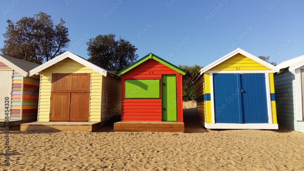 Front view of Brighton Bathing Boxes under bright blue sky Front view of Brighton Bathing Boxes under bright blue sky