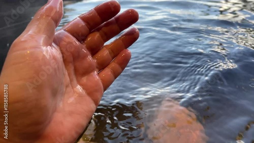 檜の露天風呂に入浴する男性が湯を手でかき混ぜるシーン photo